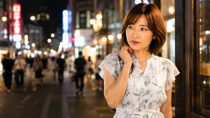 夜の歓楽街を一人で歩く女性
